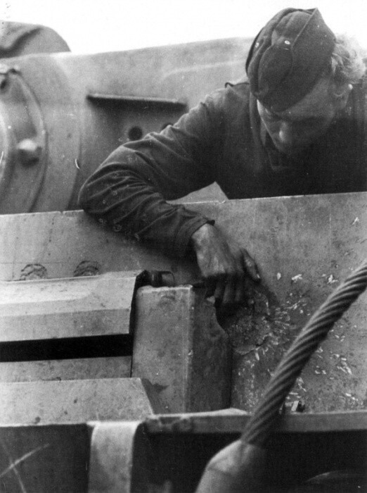 Немецкий танкист осматривает след от попадания советского снаряда на лобовой броне танка PzKpfw. V «Тигр». Курская дуга. 