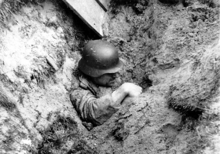 Засыпанный землей при близком взрыве авиабомбы немецкий солдат пытается выбраться. Он действительно жив — есть кинохроника с этим эпизодом, где видно, как солдат рукой разгребает землю. 