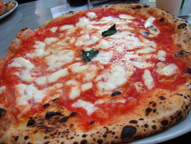 Пицца в L'Antica Pizzeria da Michele в Неаполе, Италия — сочная и хрустящая. Здесь готовят традиционные пиццы маринара и маргарита с 1906 года.
