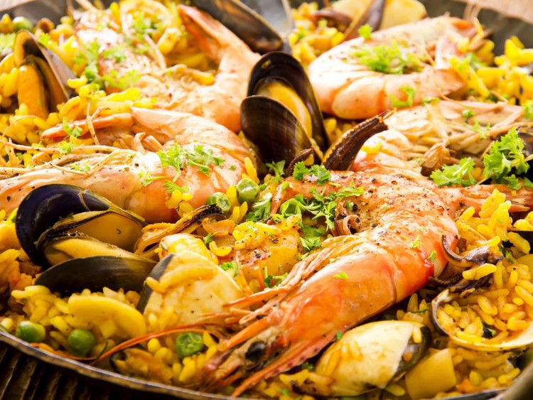 Разделите с друзьями горшок паэльи — риса с морепродуктами и чоризо, приправленного шафраном, — в Can Majó, знаменитом ресторане на побережье Барселоны, Испания.