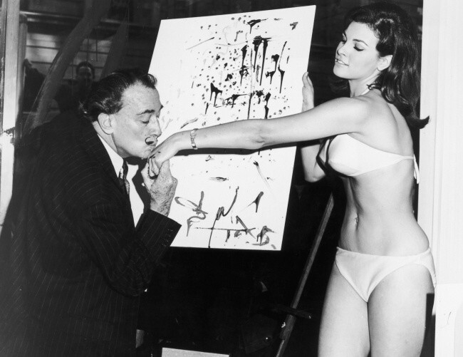 Сальвадор Дали целует руку актрисе Ракель Уэлч на фоне ее абстрактного портрета, 1965.