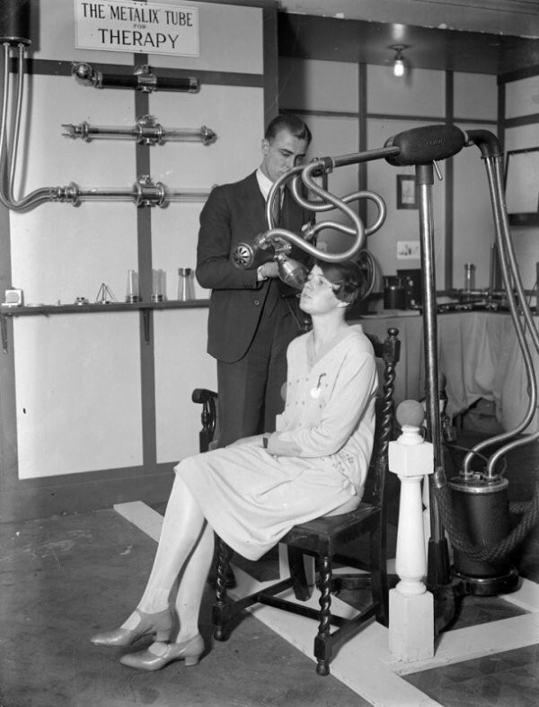 Мужчина и женщина демонстрируют медицинское оборудование на выставке рентгена, 1928
