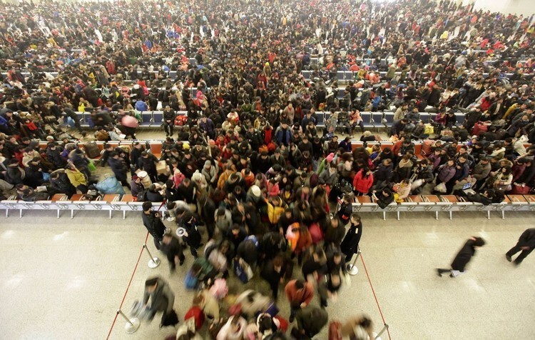 21. Пассажиры ждут посадки на поезд в здании вокзала Ханькоу в городе Ухань, Китай.