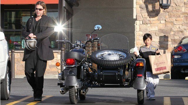2. Брэд Питт рядом со своим колясочном мотоцикле «Урал» и сыном Паксом