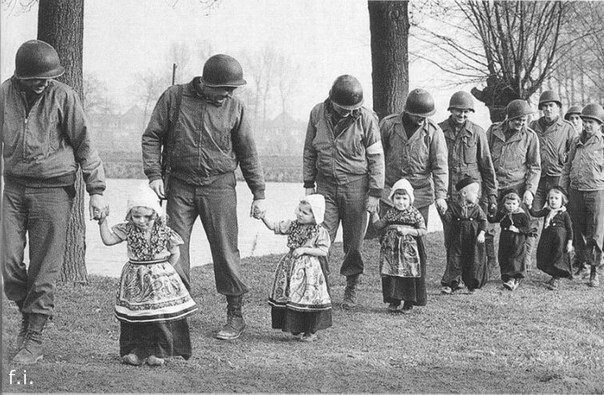 Американские солдаты ведут голландских детей на танцы, 1945 год. 