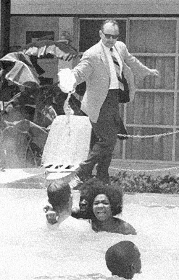 Владелец отеля выливает кислоту в бассейн, в котором плавают темнокожие, ок. 1964 года.