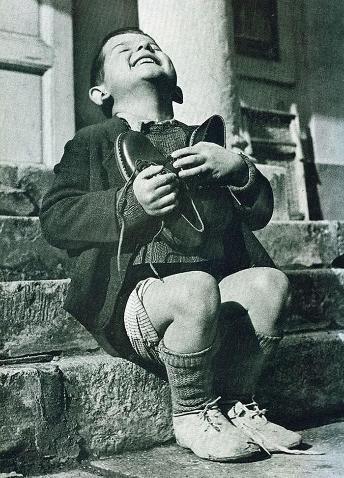 Австрийский мальчик только что получил в подарок новые туфли. Снимок сделан во время Второй мировой войны.