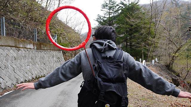 На самом деле в красных кругах на фото этого японца ничего нет, так как это реальный красный круг на палке, торчащий из его рюкзака