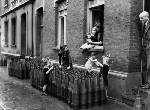 Голландские дети играют у 155-мм американских снарядов М107 на улице города, 1944 г