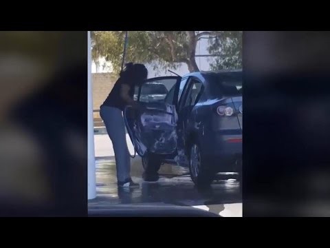 Женщина тщательно вымывает свой автомобиль 