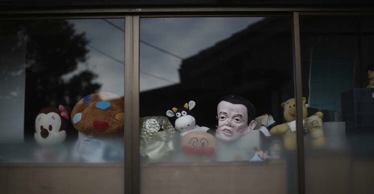 Игрушки и маски в окне дома