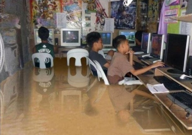 Дети играют в компьютерные игры после наводнения на Филиппинах