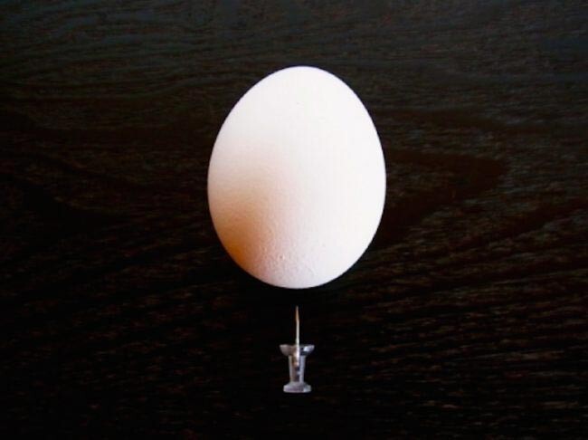 2.	Проткните канцелярской кнопкой, булавкой или иголкой маленькое отверстие в закругленной («тупой») части яйца
