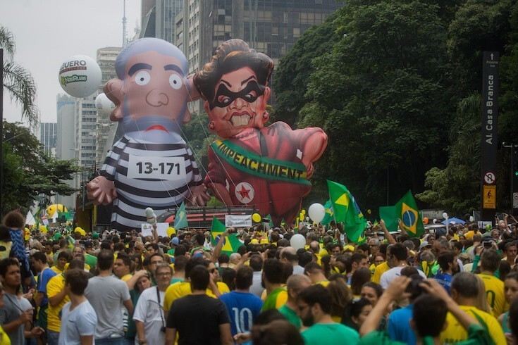 В марте 2016 г. в Бразилии тысячи протестующих - включая эти карикатурные надувные фигуры - заполнили улицы Сан-Паулу.