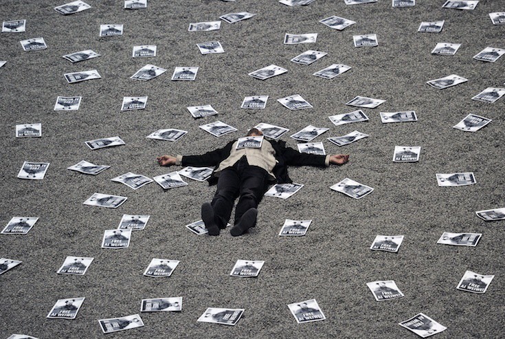 Протестующий лежит на инсталляции "Семена подсолнечника" китайского художника Ай Вэйвэя в лондонском музее Тэйт Модерн, вокруг - листовки с призывом освободить художника, находившегося в то время в китайской тюрьме.