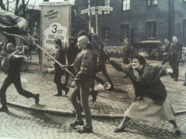 Шведка (по-видимому, пережившая концлагерь) бьет сумкой неонациста