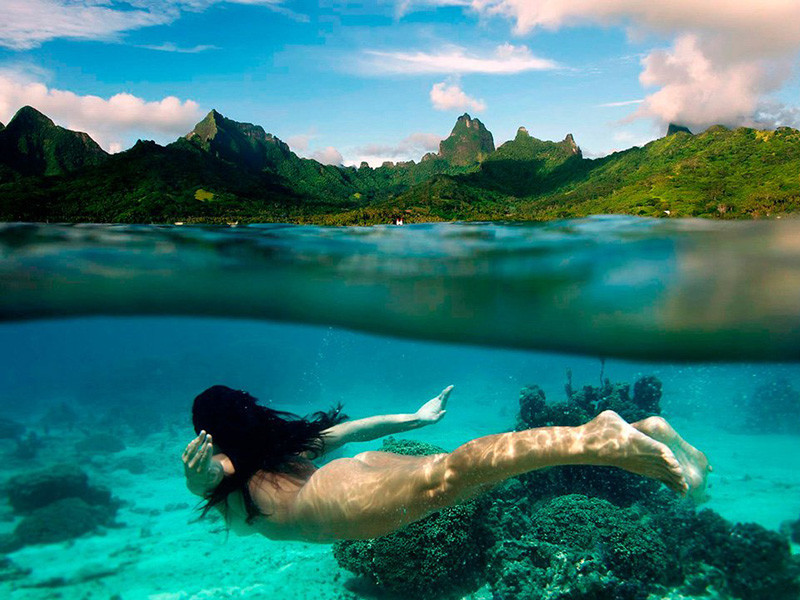 Девушка плавает у побережья острова Муреа в Тихом Океане в 17 километрах к северо-западу от Таити.