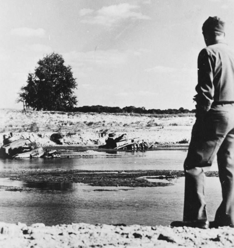 Американский солдат смотрит на немецкие танки, увязшие в реке под Полтавой