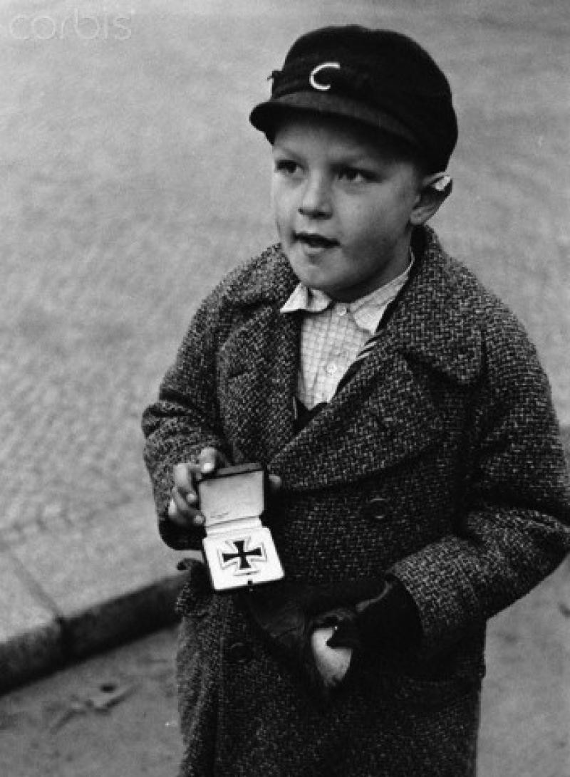 Немецкий мальчик пытается продать Железный Крест отца, Берлин, 1945 год.