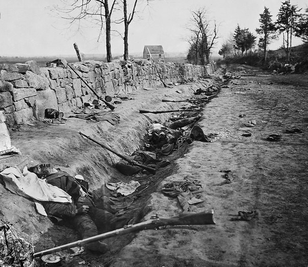 Погибшие солдаты армии Конфедерации лежат возле своих ружей за каменной стеной у подножья холмов Marye’s Heights близ Фредериксберга, штат Вирджиния, 3 мая 1863 года.