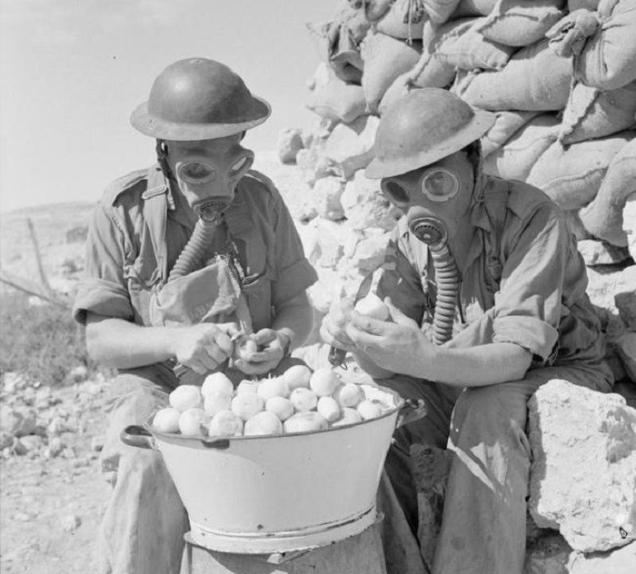 Британские солдаты в противогазах чистят лук, 15 октября 1941 года 