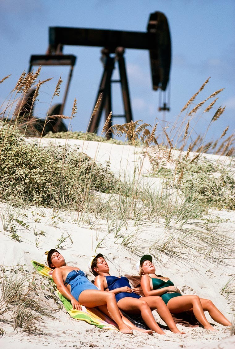 Женщины загорают на фоне нефтяной качалки, 1980 год, Остров Падре, Техас, США