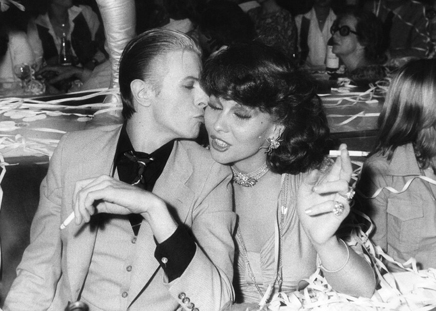 Дэвид Боуи и нидерландская певица и актриса Роми Хааг наслаждаются сигареткой в клубе Alcazar в Париже, 1976 год