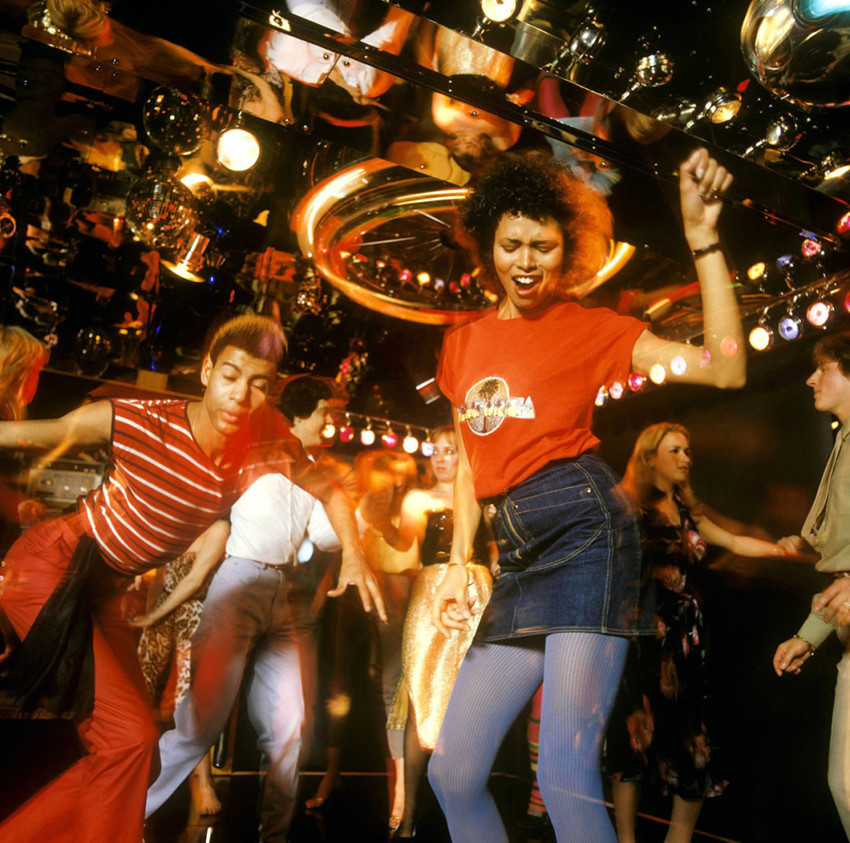 Группа молодежи отрывается на зеркальном танцполе, около 1978 года
