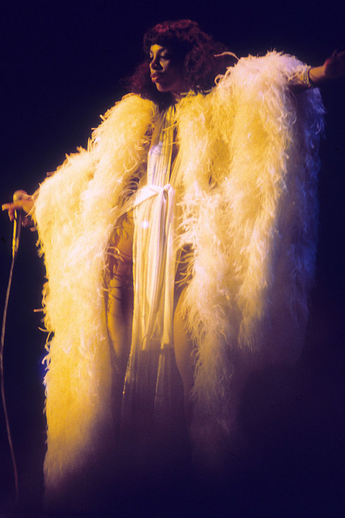 Королева диско Донна Саммер выступает на сцене в костюме из перьев, около 1976 года