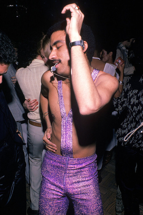 Мужчина в сверкающем фиолетовом наряде дует в свисток на танцполе клуба Studio 54 в Нью-Йорке, 1979 год
