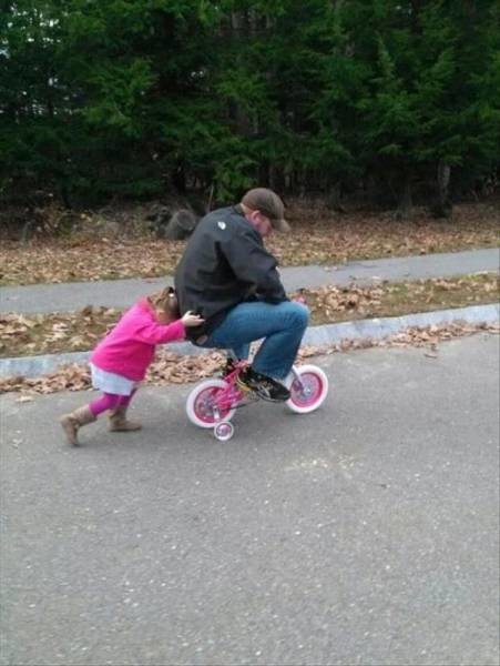 Учит папу кататься на велосипеде 