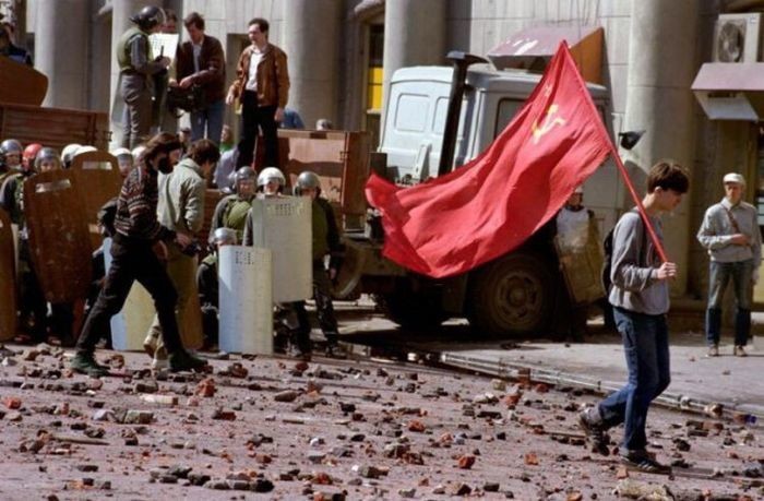 Одинокий демонстрант-коммунист, идущий по усыпанной камнями улице после кровопролитного столкновения с правоохранительными органами,1993 год