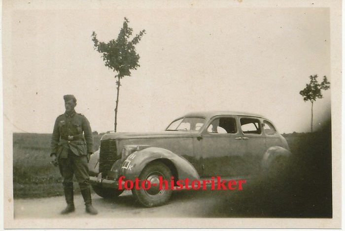 Немецкий солдат у трофейного автомобиля "Studebaker 4C".