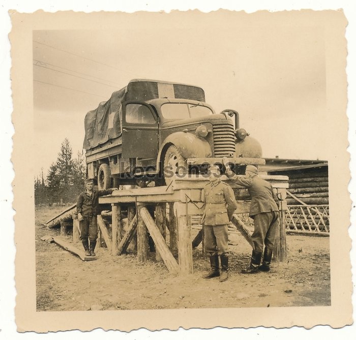 Солдаты немецкой армии у стоящего на эстакаде американского грузовика " Chevrolet" 1939 года.