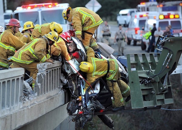 1. Пожарные, спасающие женщину из ее автомобиля, который врезался в ограждение моста.