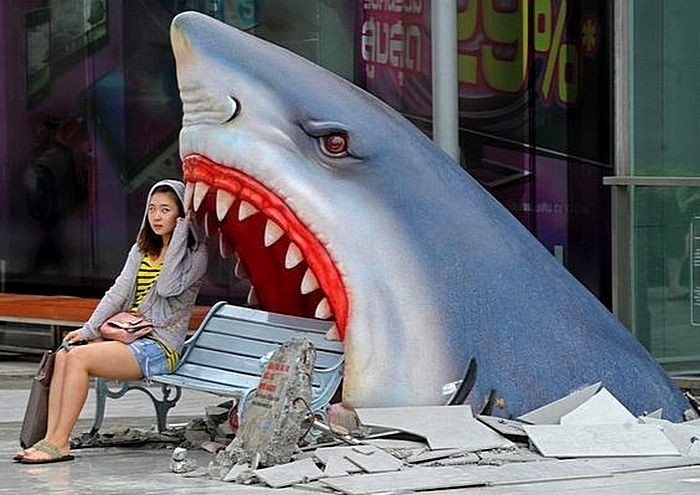 15. Туристка сидит рядом с скульптурой акулы в торговом центре в Бангкоке