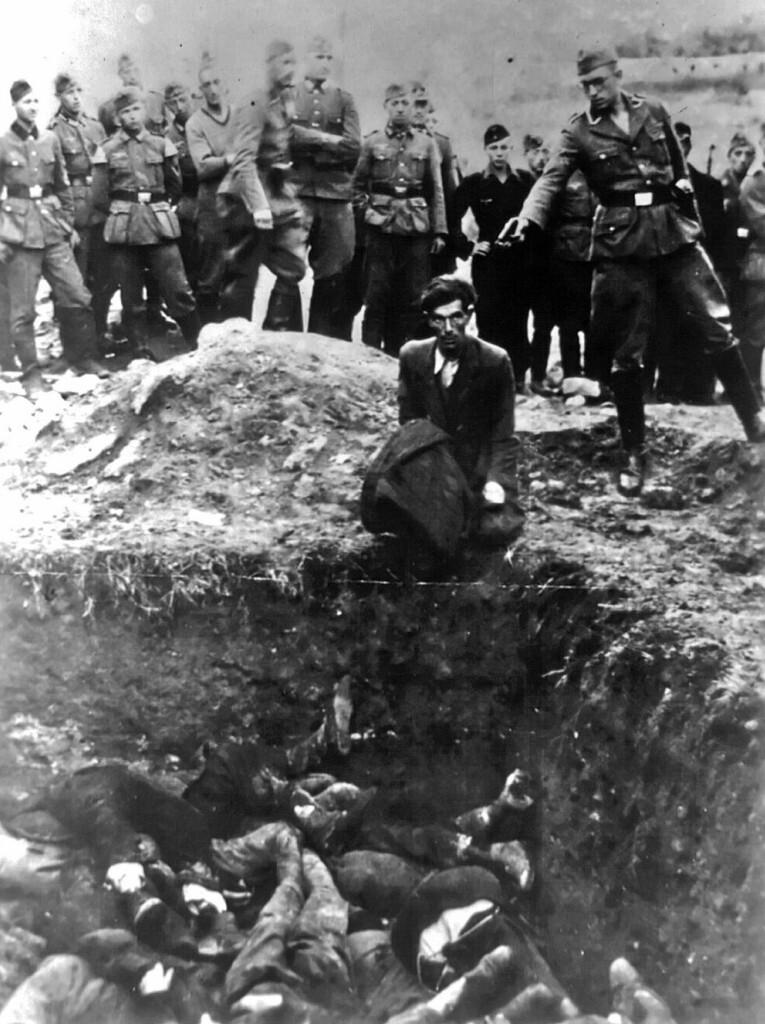 Немецкий солдат  стреляет в украинских евреев во время массовых расстрелов в  Виннице, Украине, между 1941 и 1943 годами.