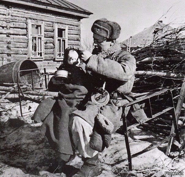 Старший сержант Моисеев кормит двухлетнюю девочку Валю, найденную им в одной ...