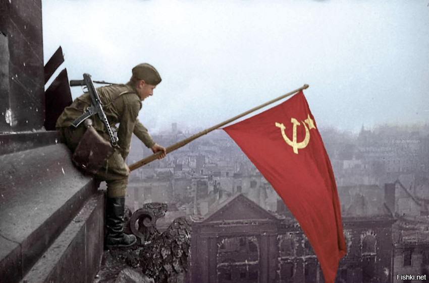 Солдат машет советским флагом в Берлине, 1945