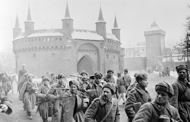 Колонна красноармейцев проходит мимо оборонительного средневекового бастиона Барбакан в освобождённом Кракове. 1-й Украинского фронт. 2 февраля 1945 года.