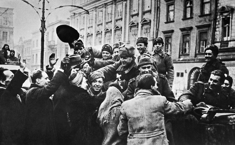 Мирные жители общаются с советскими бойцами и командирами на улице освобождённого Кракова. Польша, 1945 год.