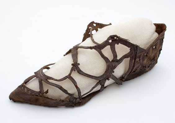Обувь: около 1600-1660, Нидерланды, кожа, украшенная скрещенными кожаными кружевами и украшениями крестов и цветочными мотивами.