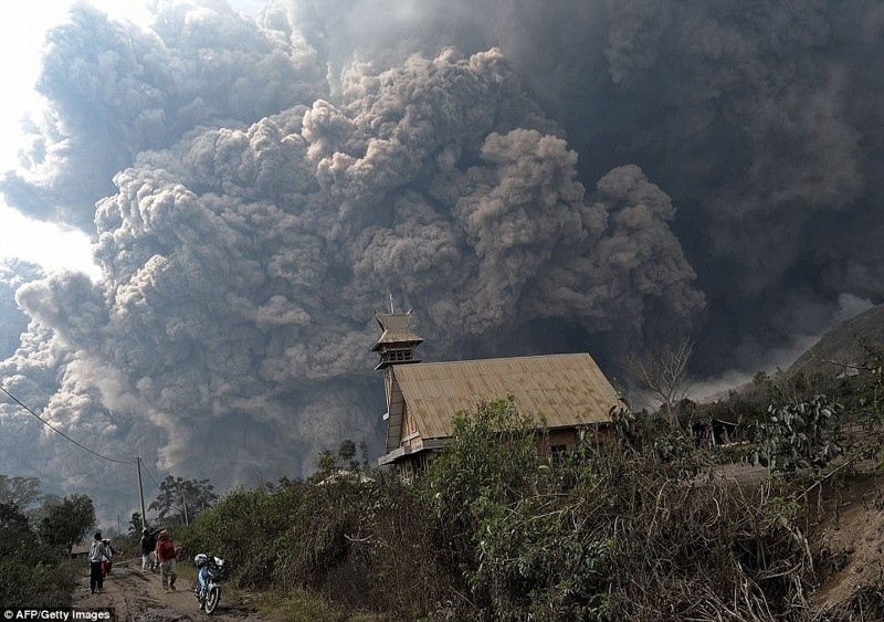 Огромное облако вулканического пепла обрушивается на деревню в округе Каро на острове Суманта в Индонезии во время извержения вулкана Синабунг 1 февраля 2014 года.