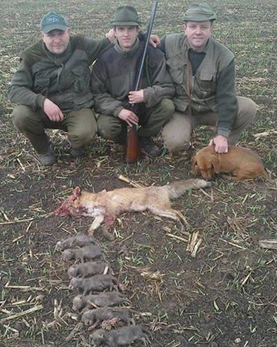 5. Охотники позирующие рядом с убитой семьей лисиц 