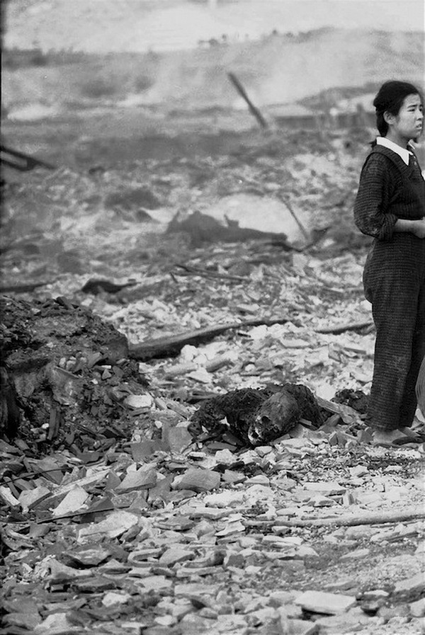 21. Девочка стоит на том месте, где был её дом в Нагасаки. И, судя по всему, там лежит то, что осталось от её матери. 