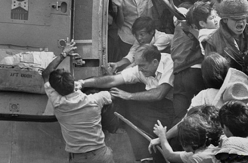 26. Сайгон, эвакуация, 30 апреля 1975 года. Американец выталкивает вьетнамца из последнего вертолета, который прибыл за сотрудниками посольства США. 
