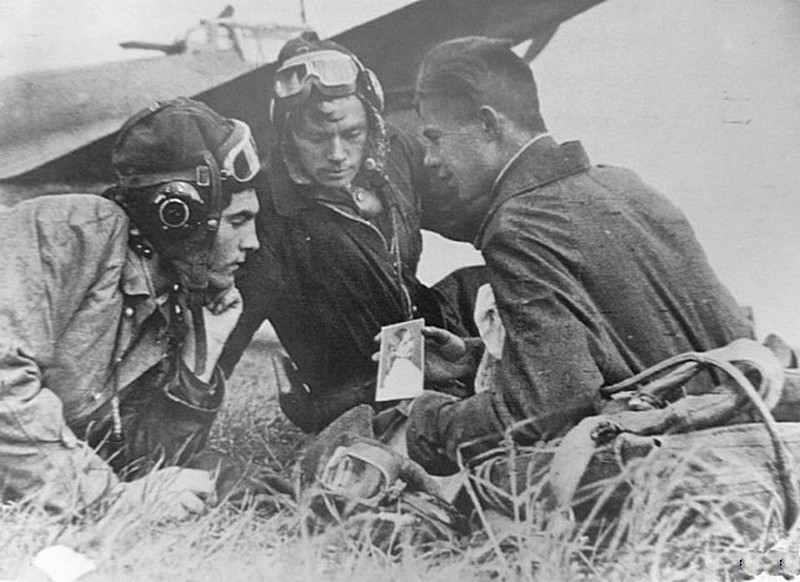22. Советский лётчик показывает товарищам фото своей девушки. 1944. 