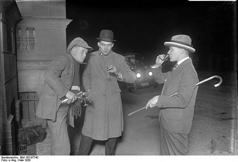 53. Нелегальный продавец алкоголя наливает по рюмочке ночью на улице Берлина. Май 1929. 