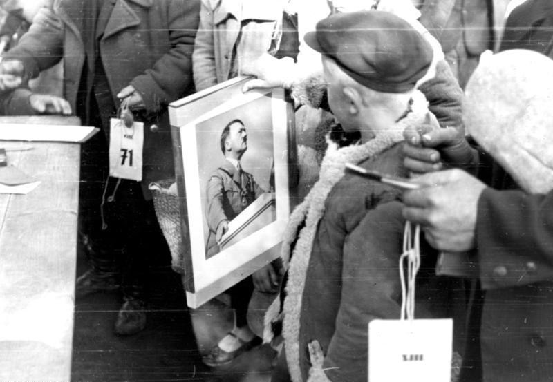 8. Раздача портретов Адольфа Гитлера для вывешивания в квартирах, лагерь для переселенцев в Люблине (Польша), 1940 г.