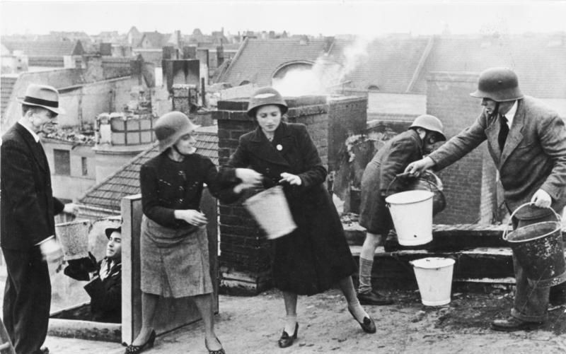 32. Мужчины, женщины и дети на тушении пожаров после авианалета, место неизвестно, 1942 г.